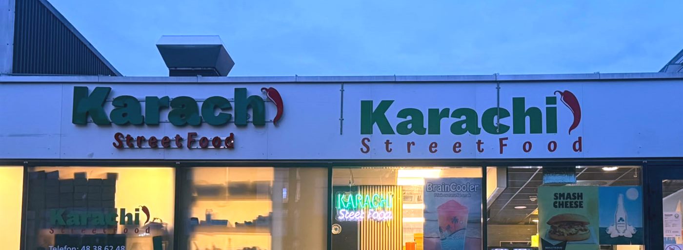 Fasaden til Karachi Streetfood med lysskilt i skumringen